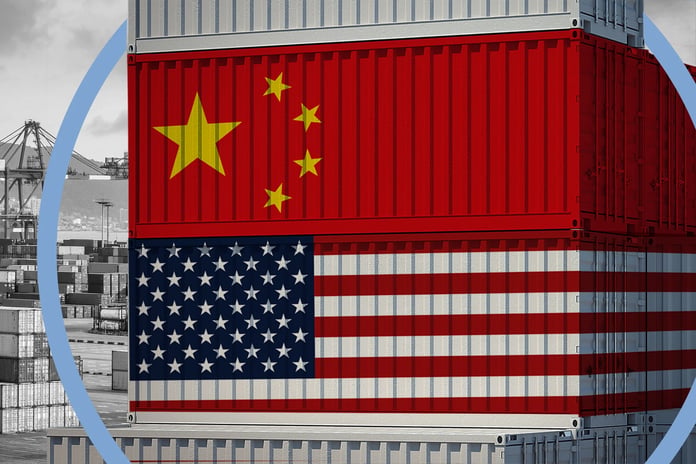 US and China flags over shipping containers at a port