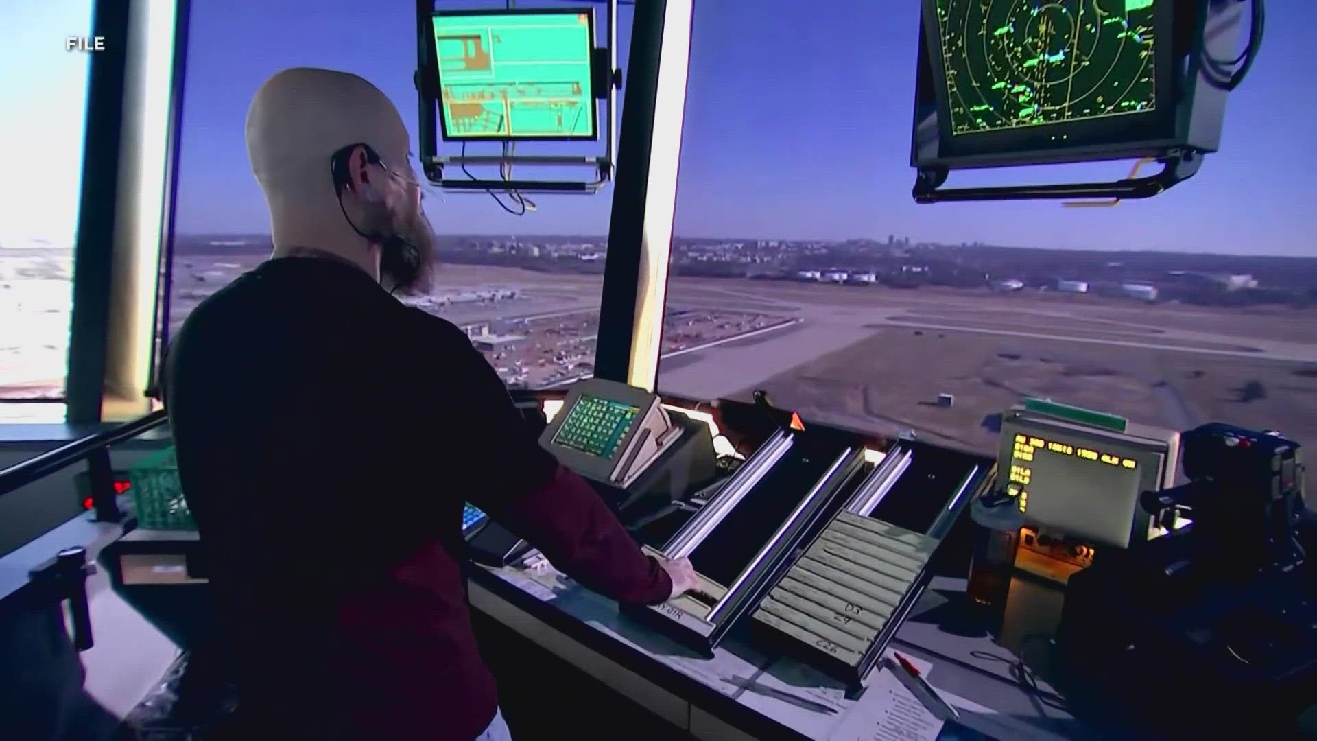 Air traffic controllers monitoring radar screens and flight data in control tower during government shutdown