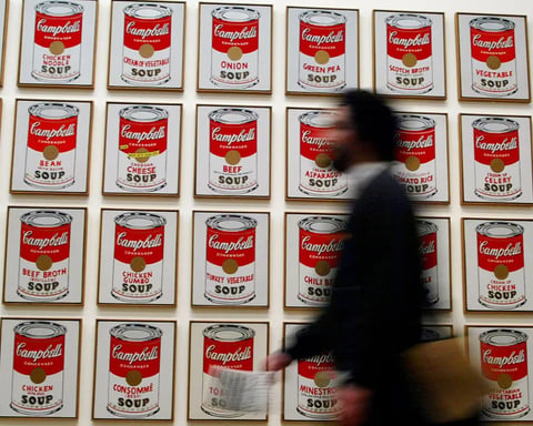 Campbell's Soup Company logo and cans on supermarket shelf
