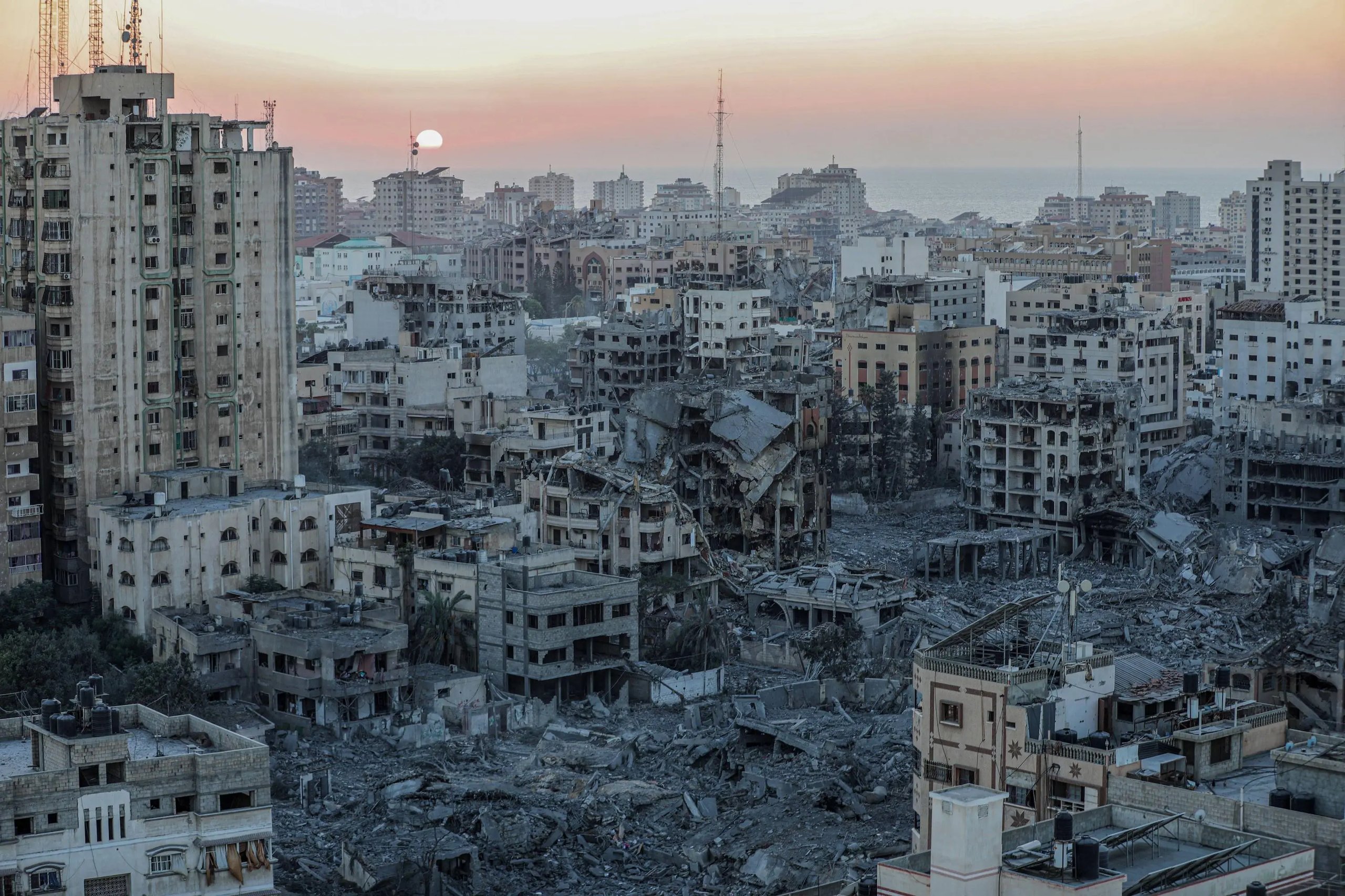 Aerial view of Gaza city showing widespread destruction and blocked aid trucks