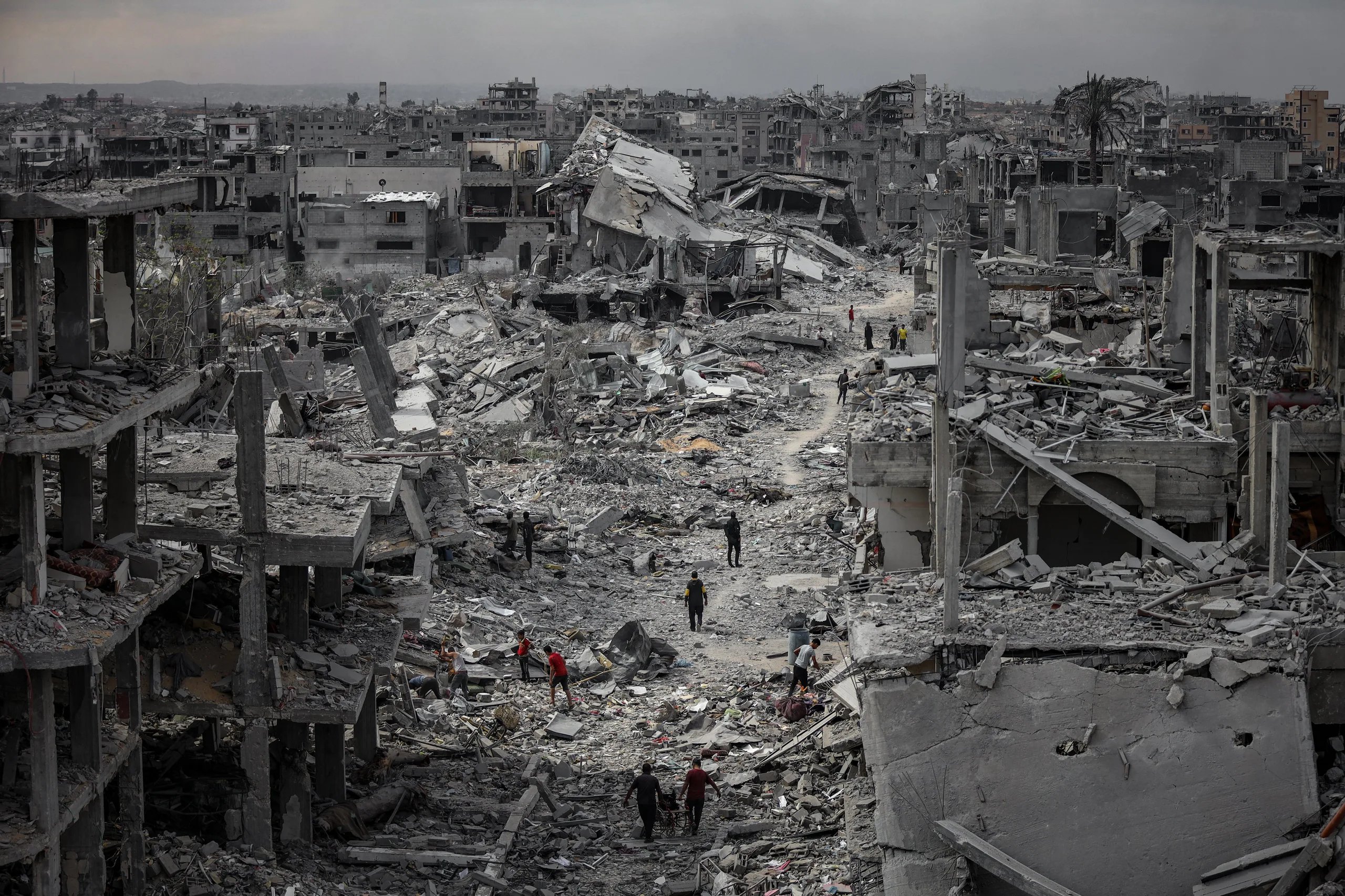 Gaza Day 716 devastation with destroyed buildings and civilians amid rubble
