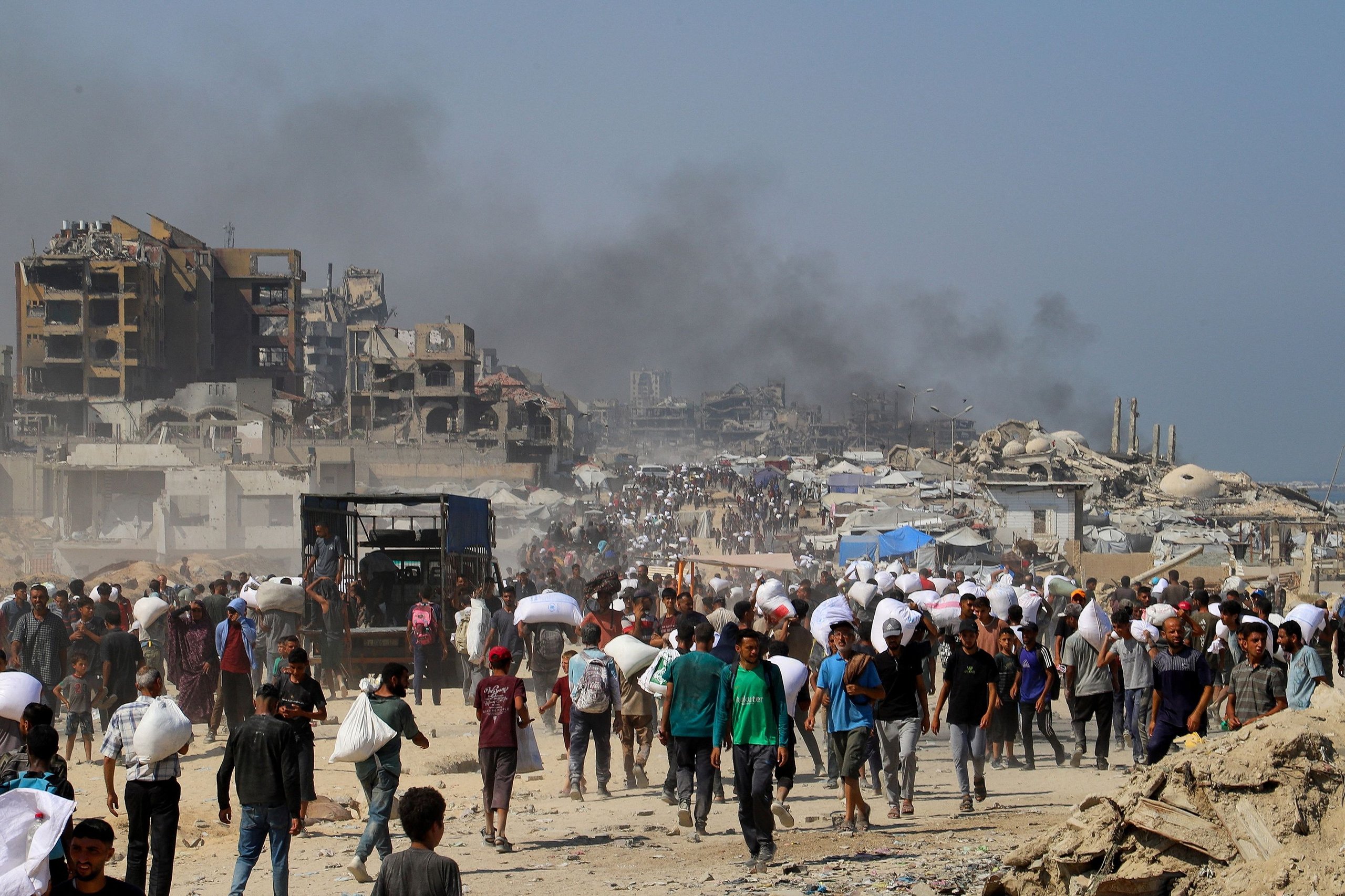 Humanitarian aid workers distribute supplies to civilians in Gaza amid crisis 2025