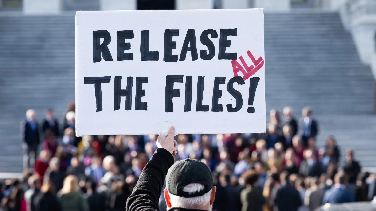 Protester holding a sign calling for the release of Jeffrey Epstein case files outside the US Capitol