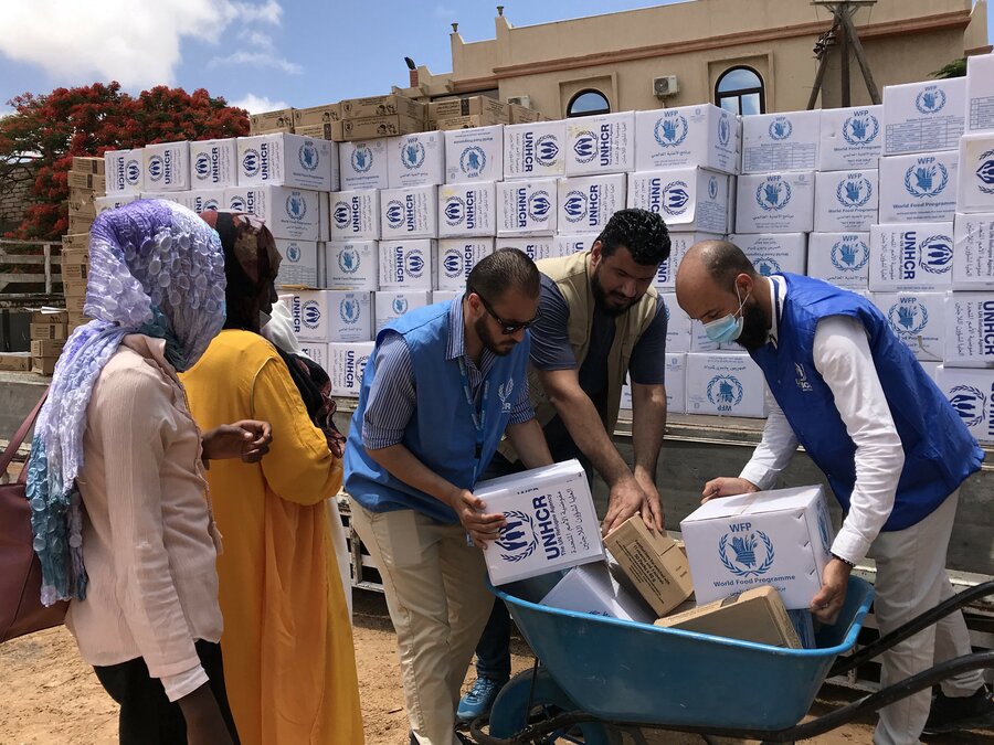 Aid Distribution at El Fasher Refugee Camp Humanitarian workers distributing food and water in refugee camp near El Fasher