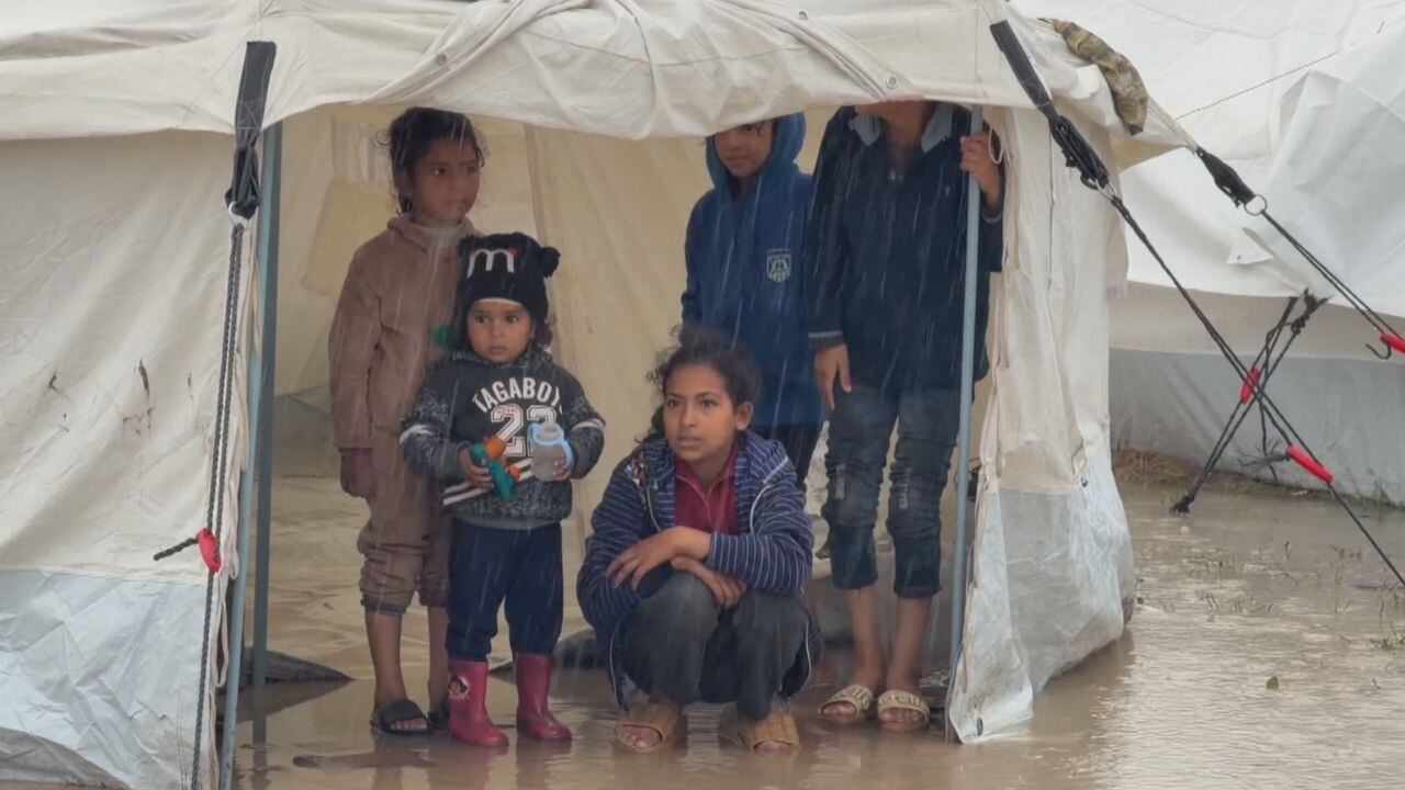 Palestinian child stands in a soaked tent after Storm Byron in Gaza.