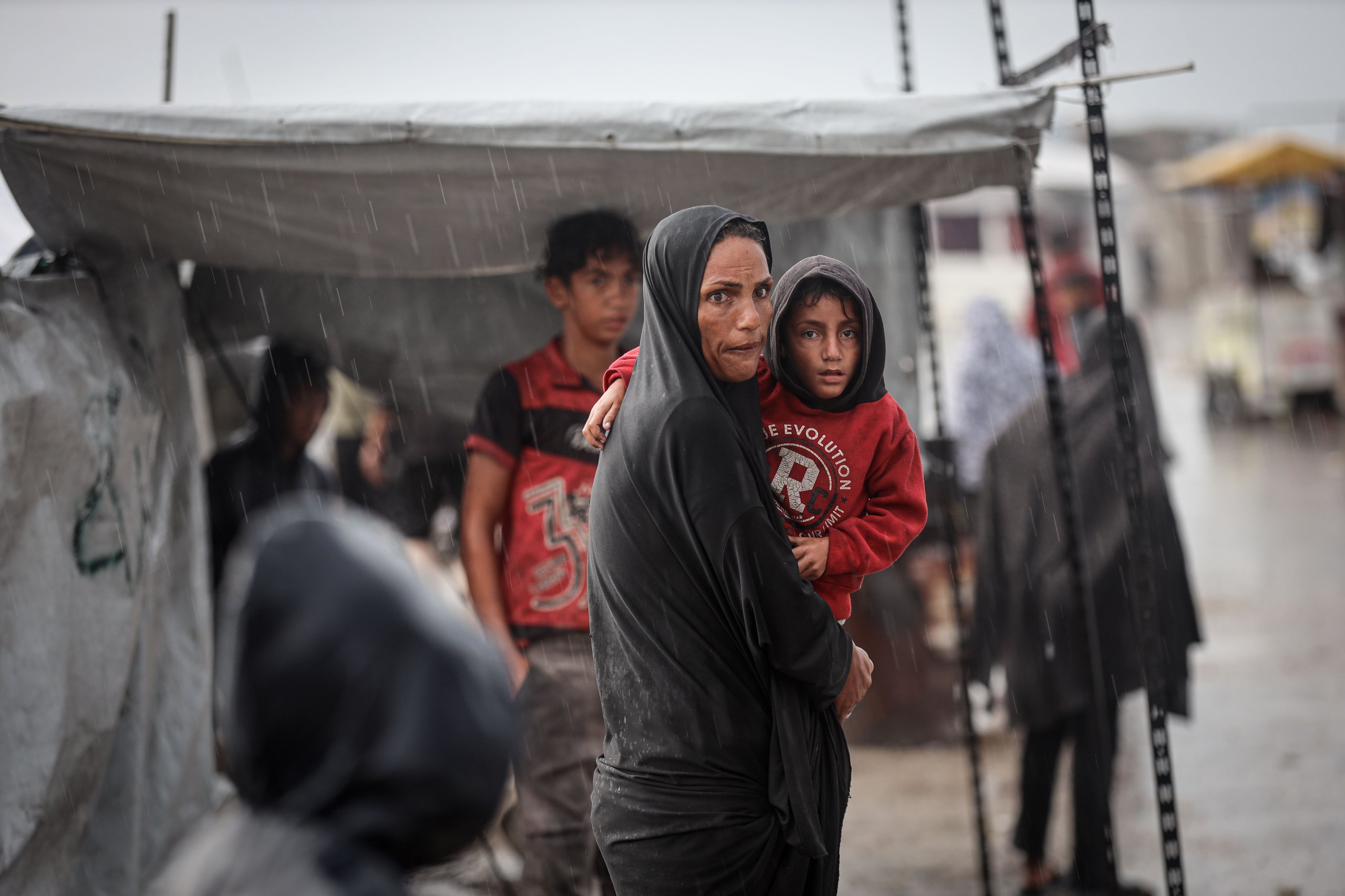 Palestinian children stand in flooded displacement camp during Storm Byron in Gaza December 2025