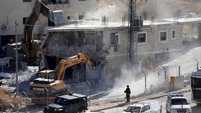 Destroyed residential buildings in Gaza City following Israeli airstrikes amid Western diplomatic support.