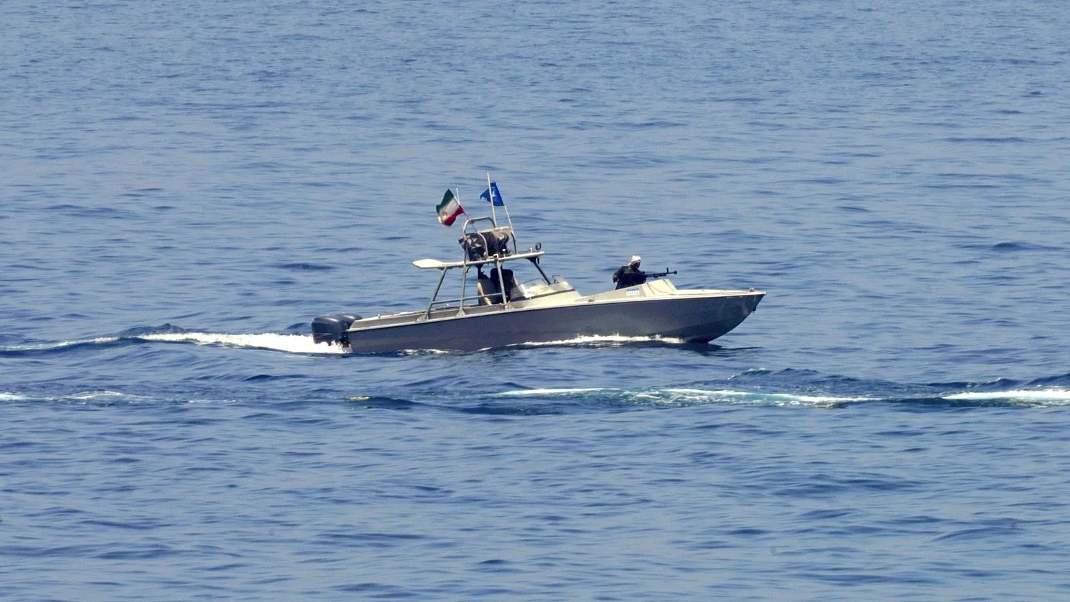 Iranian naval patrol boats near oil tankers in the Strait of Hormuz