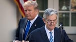 Federal Reserve Chair Jerome Powell speaks at a podium with a stern expression as he discusses the DOJ investigation into his leadership.