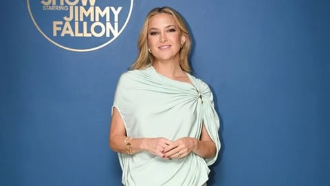 Kate Hudson wearing a mint green one-shoulder Sportmax dress with a thigh-high slit on The Tonight Show Starring Jimmy Fallon in 2026.