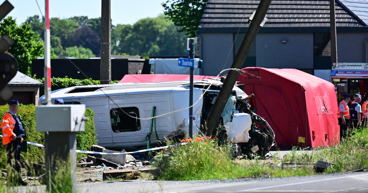 Emergency services at the scene of the train and school minibus crash at the Vierhuizen level crossing in Buggenhout, Belgium