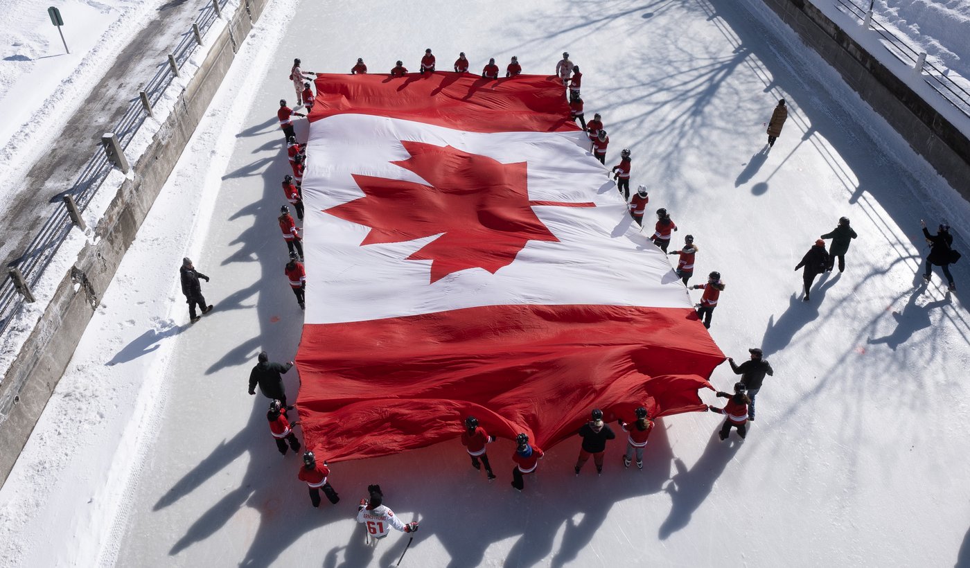 Young skaters carry a large Canadian flag on the Rideau Canal in Ottawa