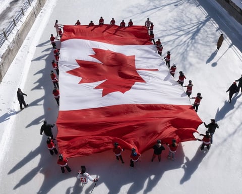 Young skaters carry a large Canadian flag on the Rideau Canal in Ottawa