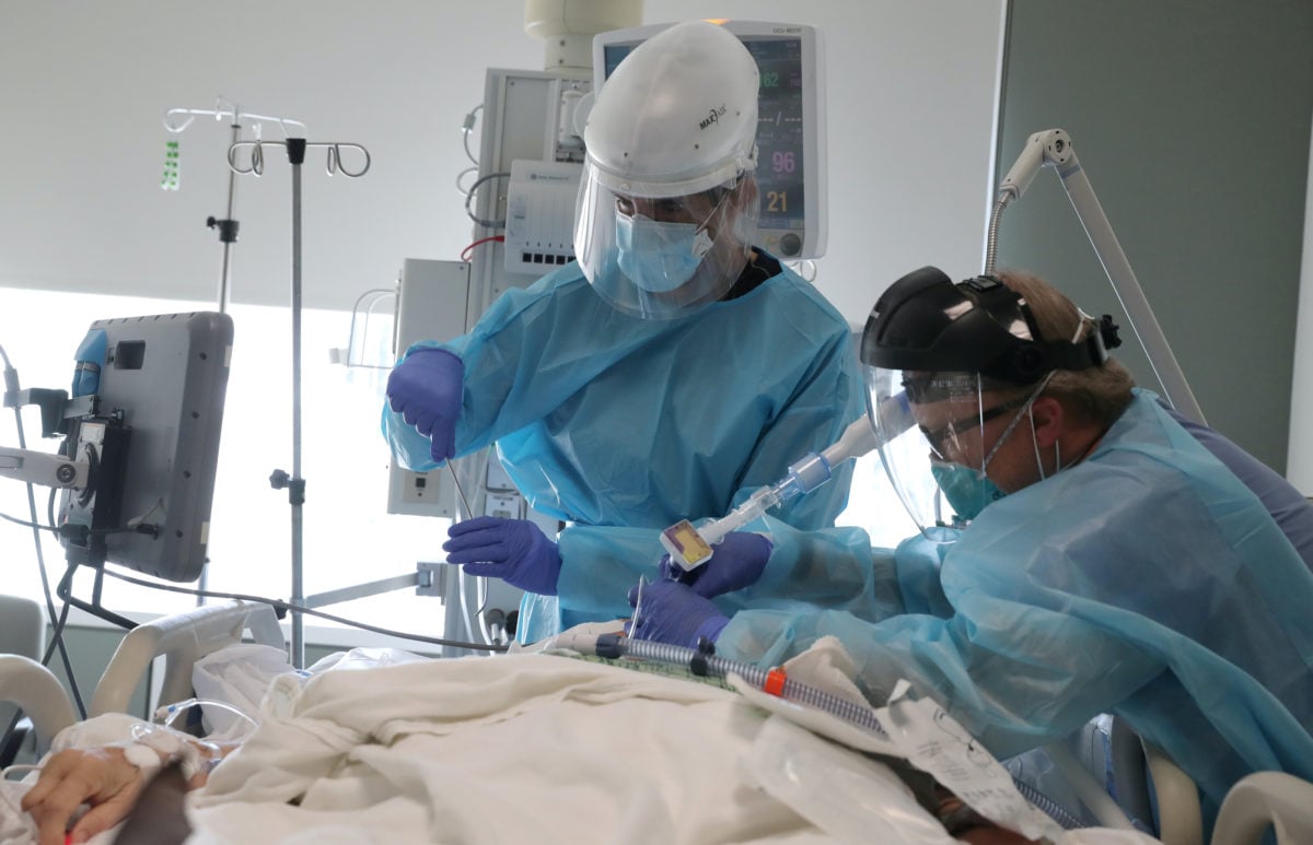 Doctors in intensive care unit monitoring a COVID-19 patient with signs of blood clot complications.
