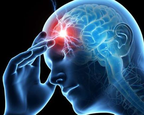 Person experiencing a migraine headache holding their head in pain