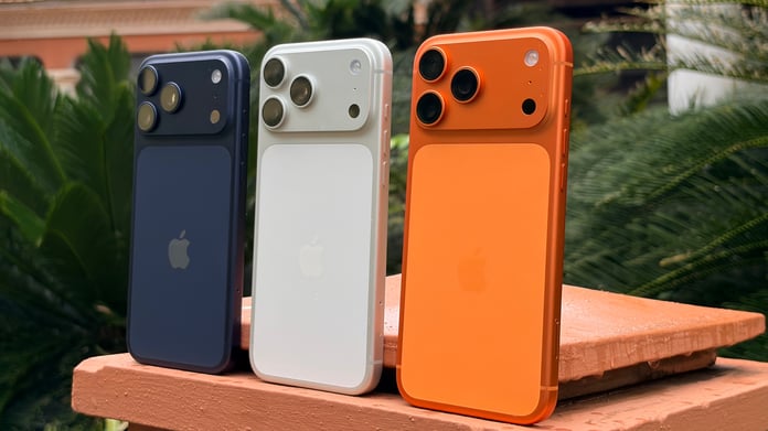 Apple iPhone 17 Pro Max in Cosmic Orange showing the forged aluminium unibody and the three 48MP rear cameras