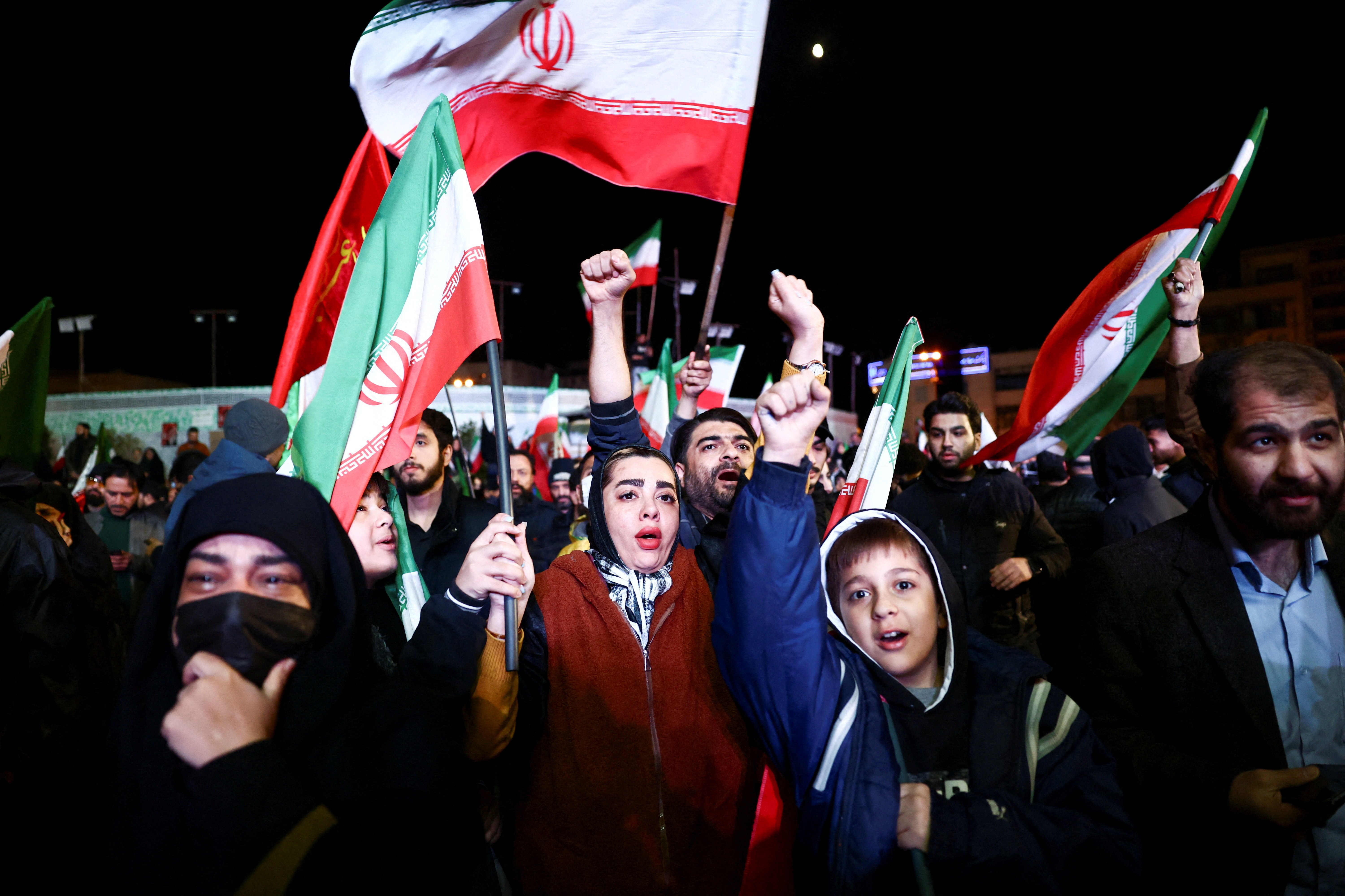 People wave Iranian flags in Tehran following the ceasefire announcement between Iran and the United States, April 2026