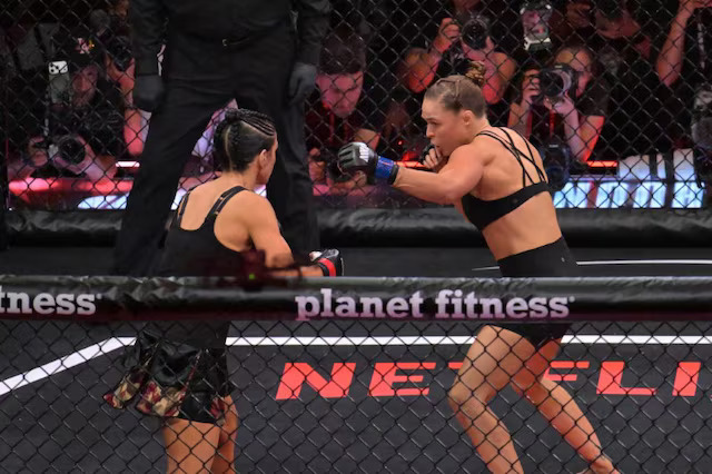 Gina Carano trapped in armbar submission by Ronda Rousey inside MMA cage
