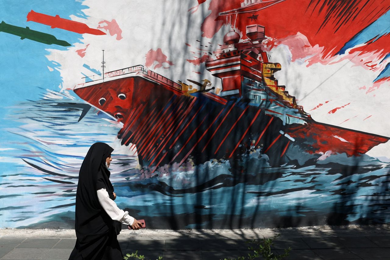A mural in Tehran depicting a US aircraft carrier under attack amid the 2026 Iran war and Strait of Hormuz crisis