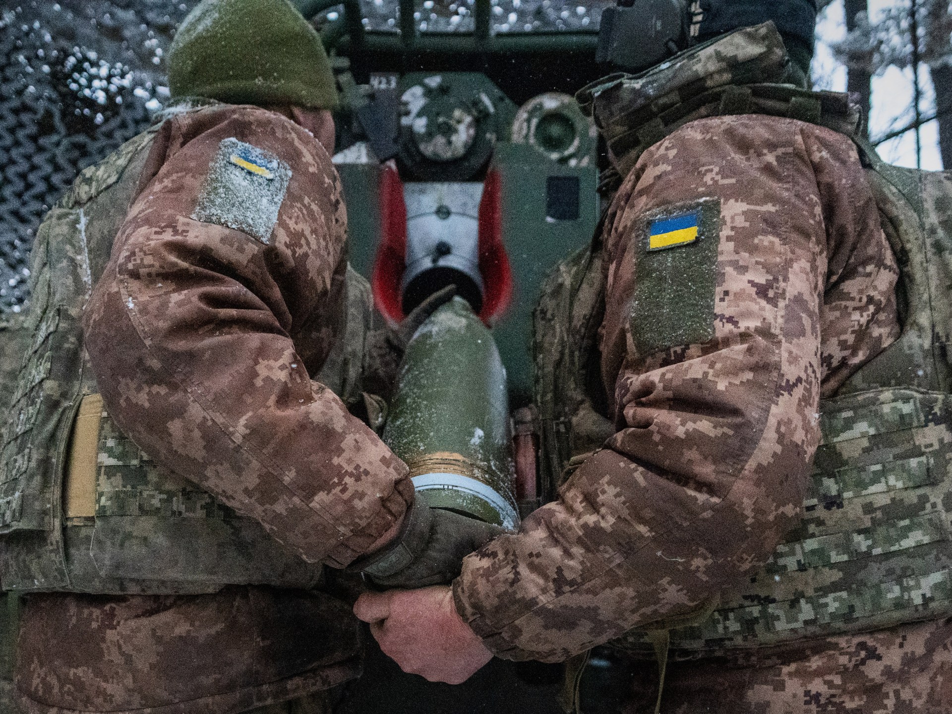 Ukrainian servicemen load an artillery shell on the Kharkiv front during the Russia-Ukraine war