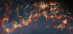 Webb Telescope near-infrared image showing Messier 51 spiral arm with young star clusters lighting bubbles inside dense gas