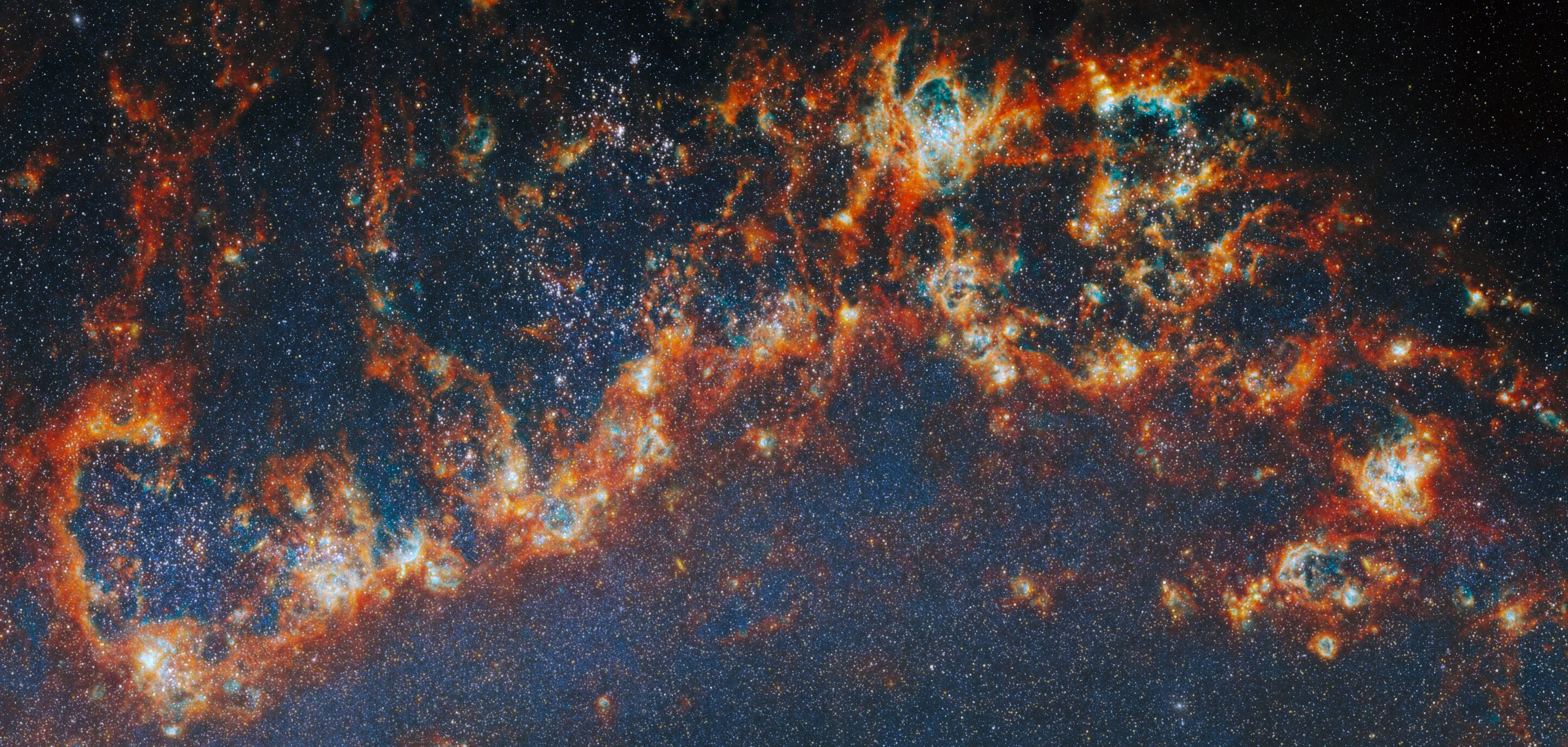 Webb Telescope near-infrared image showing Messier 51 spiral arm with young star clusters lighting bubbles inside dense gas