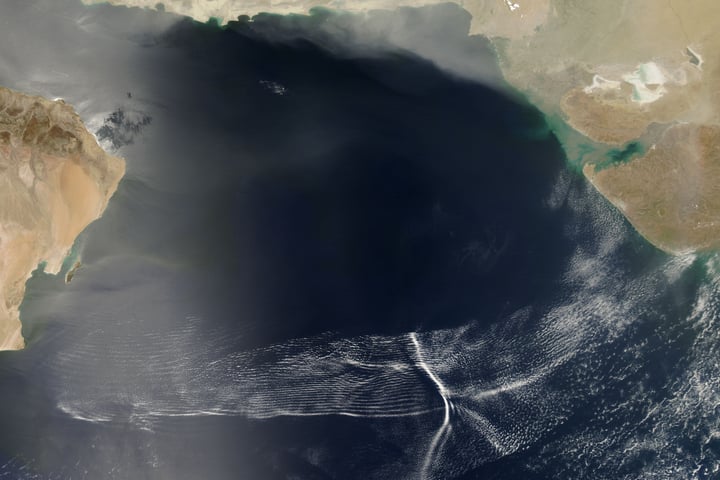 NASA MODIS satellite image from the Aqua satellite showing a massive cluster of wave clouds spanning the Arabian Sea from Oman to western India during a monsoon system advance