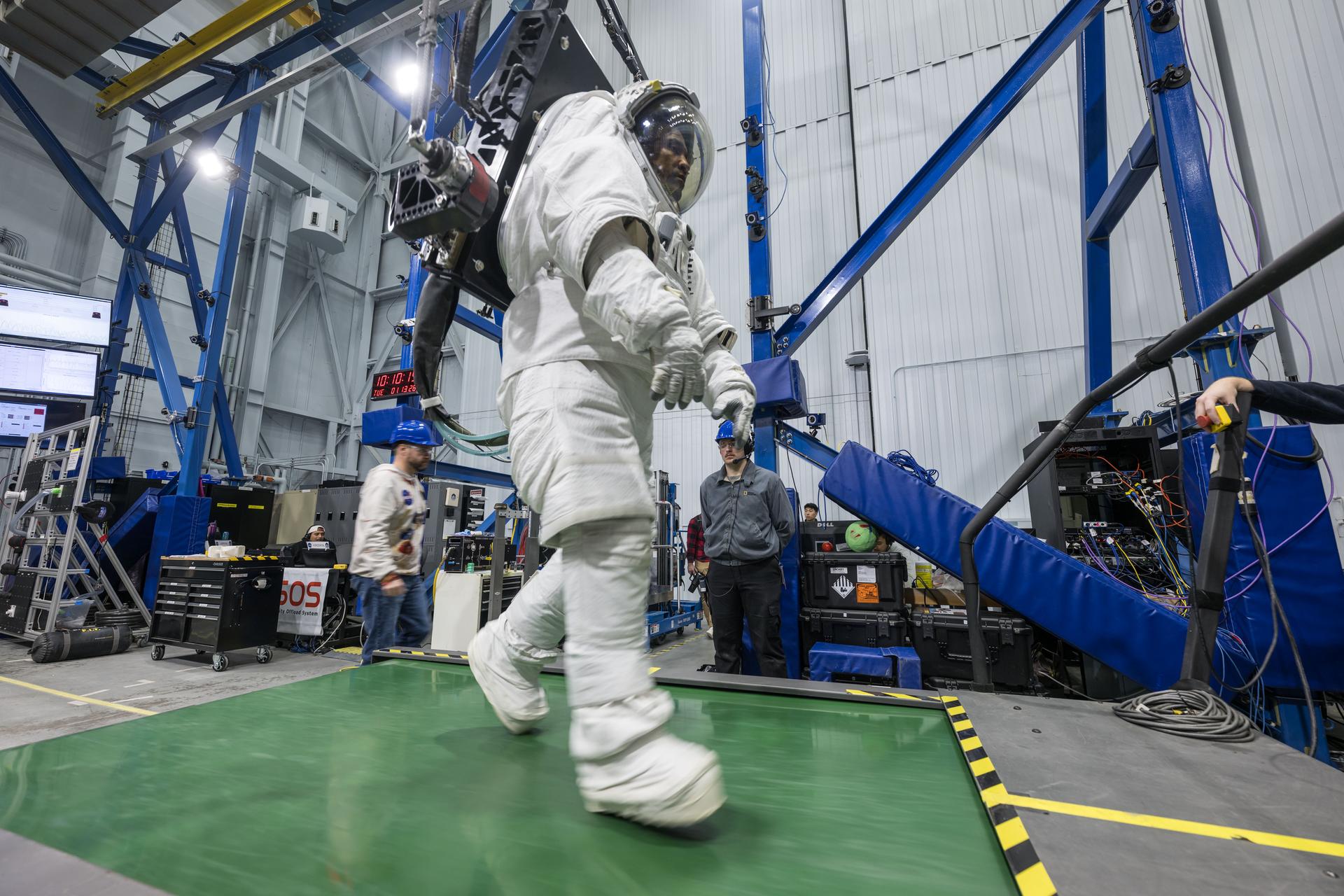 Artemis II astronaut Victor Glover walks on a treadmill in a spacesuit harnessed to NASA's Active Response Gravity Offload System simulating lunar gravity