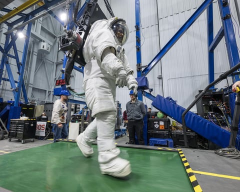 Artemis II astronaut Victor Glover walks on a treadmill in a spacesuit harnessed to NASA's Active Response Gravity Offload System simulating lunar gravity