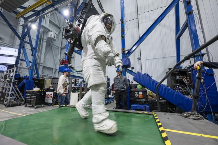 Artemis II astronaut Victor Glover walks on a treadmill in a spacesuit harnessed to NASA's Active Response Gravity Offload System simulating lunar gravity