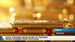 Gold bars and trading charts as gold settles near $4,000 per ounce