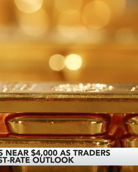 Gold bars and trading charts as gold settles near $4,000 per ounce