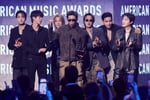 BTS members accepting the Artist of the Year award on stage at the 2026 American Music Awards at MGM Grand Garden Arena in Las Vegas