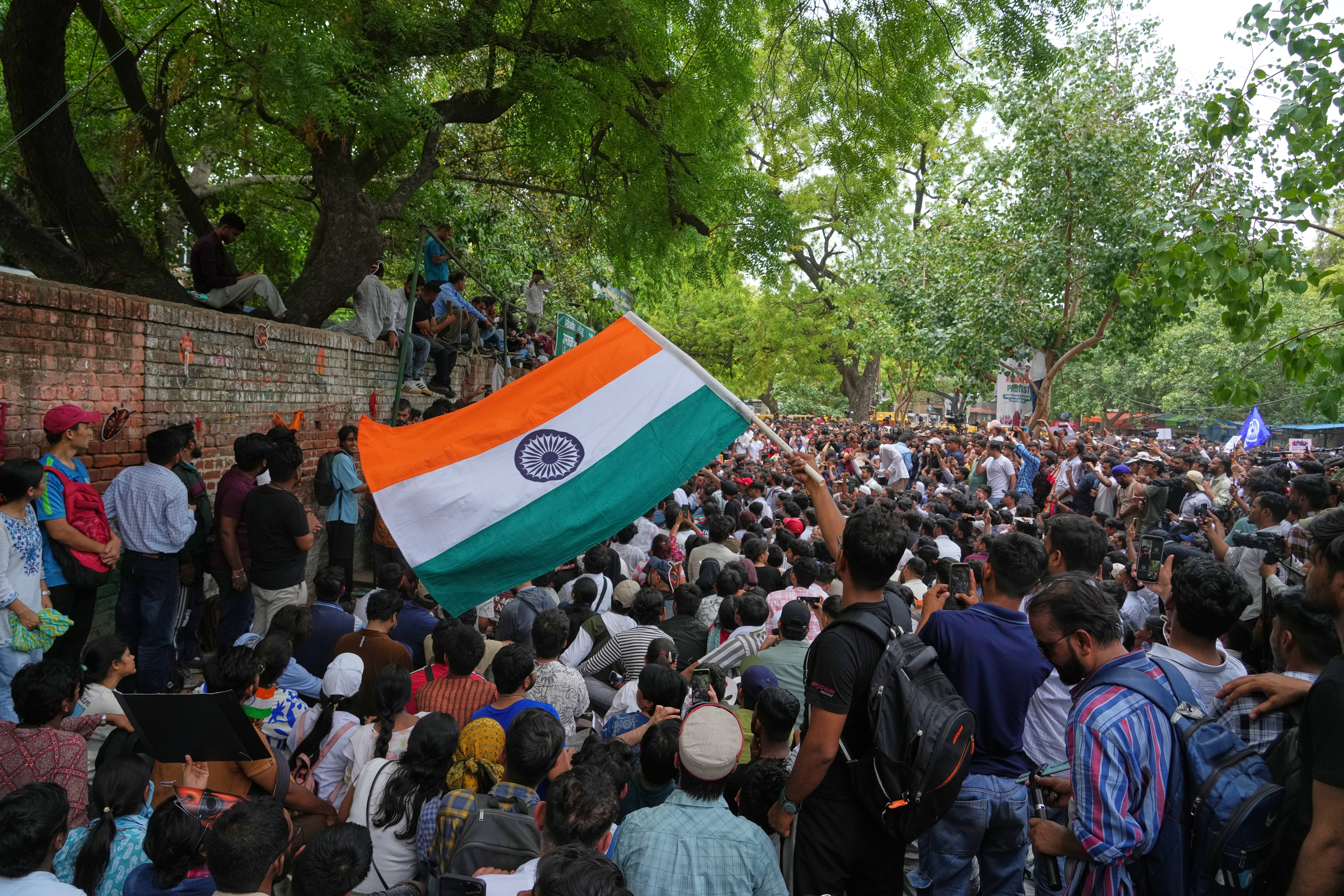 Cockroach Janta Party protesters carry national flags and books symbolising education rights at the New Delhi rally over exam failures