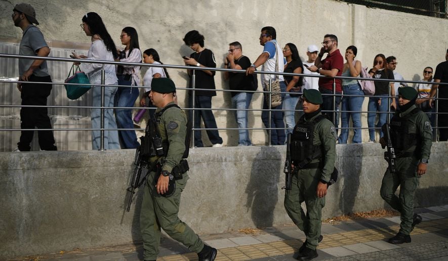 Soldiers patrol as voters arrive at a polling station during Colombia's presidential election in Barranquilla