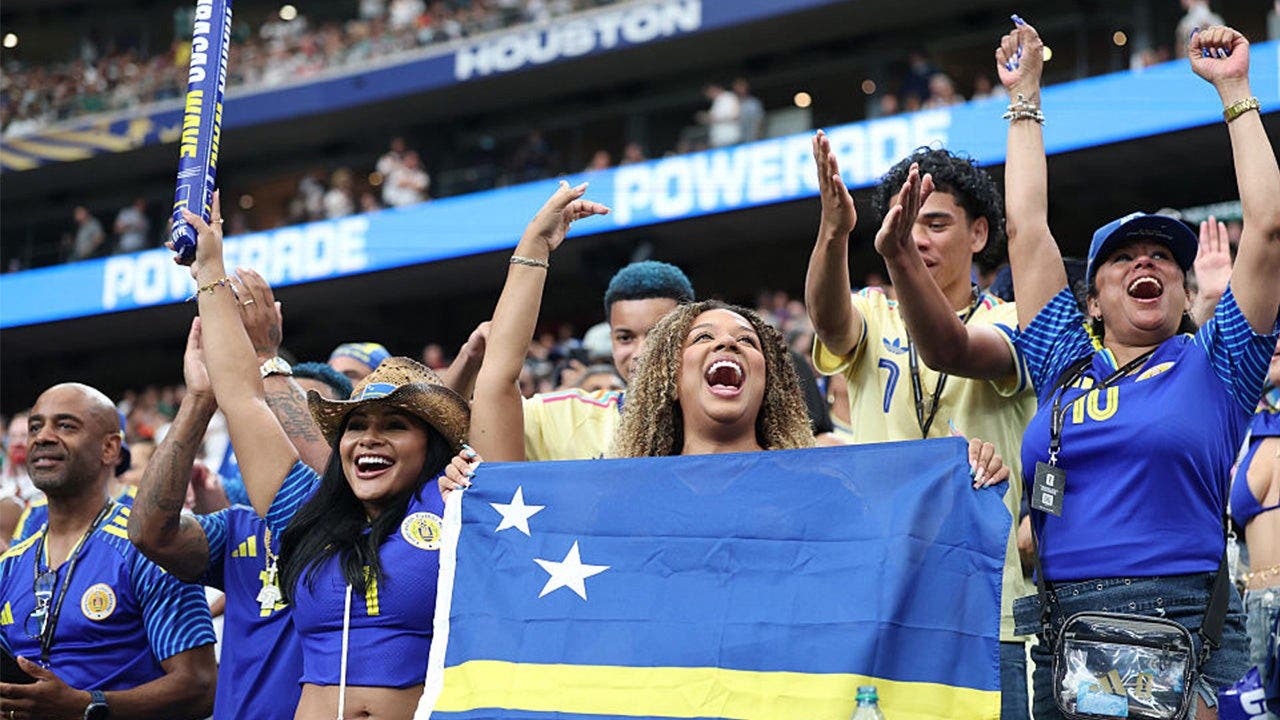 Curaçao supporters wave the national flag in the stands during their World Cup debut against Germany at NRG Stadium, Houston, June 14, 2026