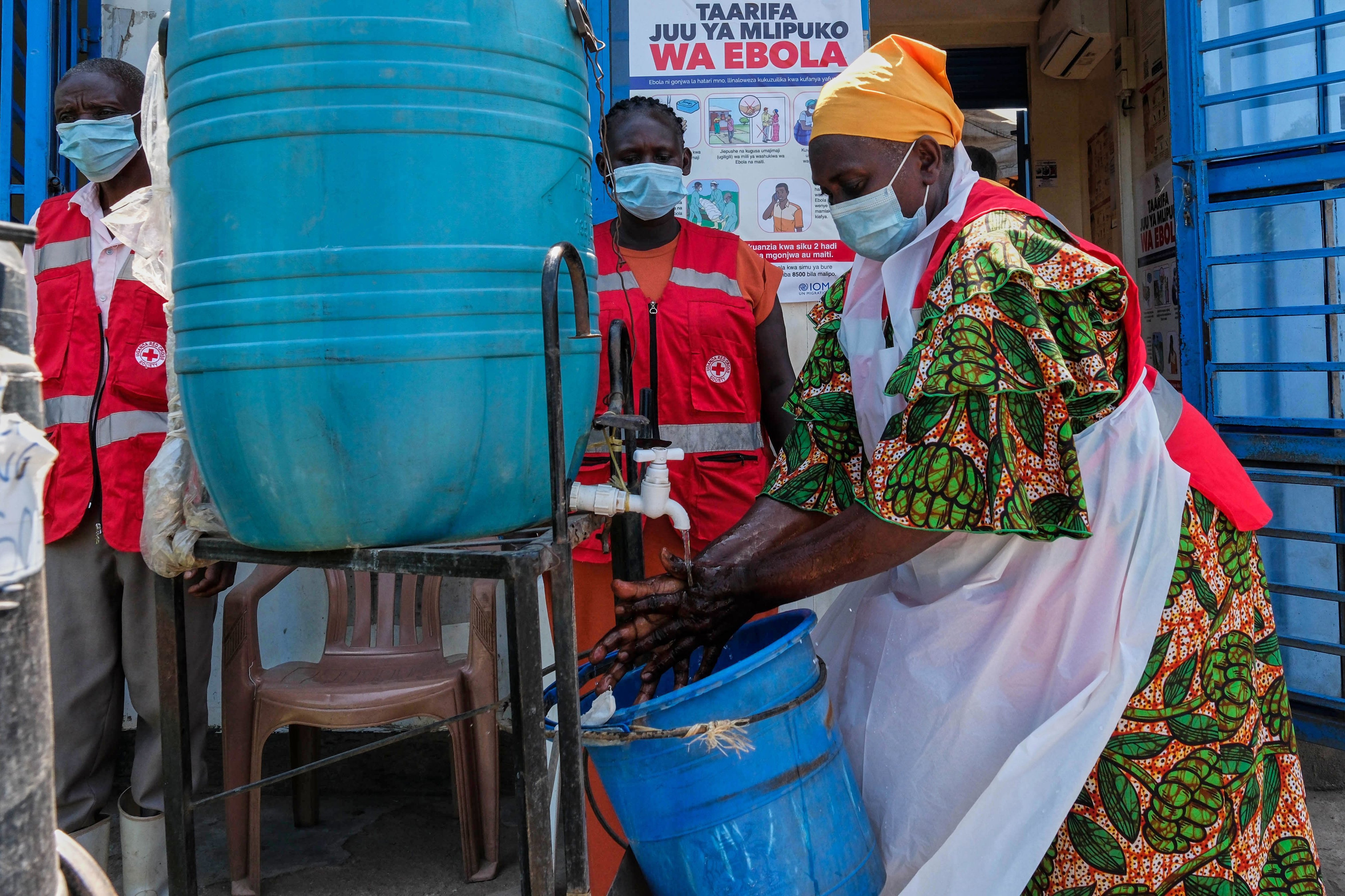 A health worker washes her hands at a temporary clinic at the Mpondwe border crossing between Uganda and the Democratic Republic of Congo