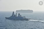 EUNAVFOR warship escorts a container ship through the Red Sea as part of EU Operation ASPIDES
