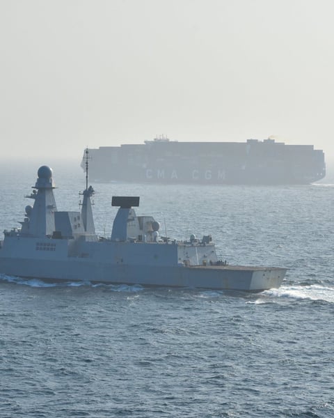 EUNAVFOR warship escorts a container ship through the Red Sea as part of EU Operation ASPIDES