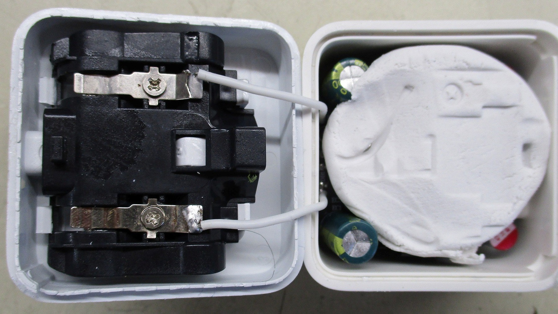Opened counterfeit phone charger revealing modelling clay inside, found by Which? in 2026 investigation into unsafe products sold on Amazon and eBay