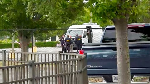 FBI agents carry out a search of an office during a federal operation