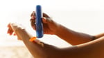 A person applies sunscreen before sun exposure