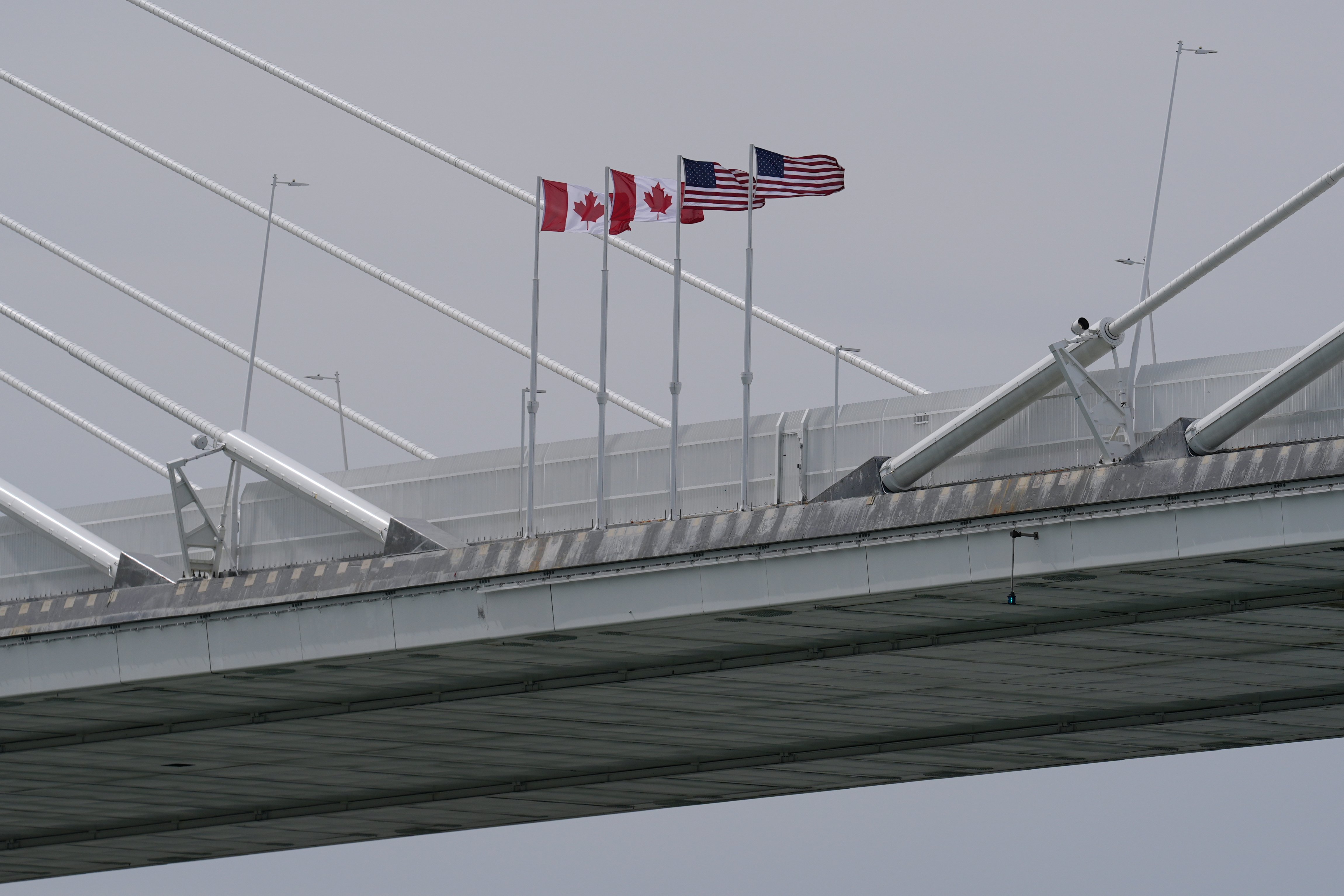 Canadian and US flags fly on the Gordie Howe International Bridge connecting Windsor, Ontario and Detroit