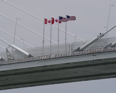 Canadian and US flags fly on the Gordie Howe International Bridge connecting Windsor, Ontario and Detroit