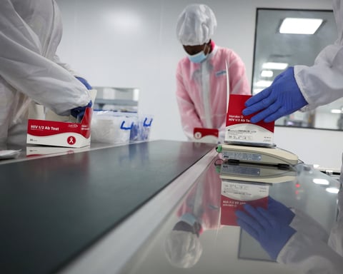 Workers package HIV test kits at a production facility in Nigeria