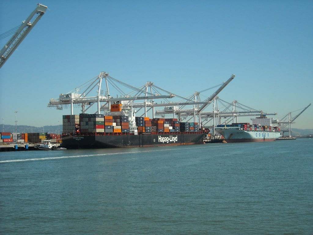 Container ships and stacked cargo containers at a port, illustrating India's record May merchandise exports
