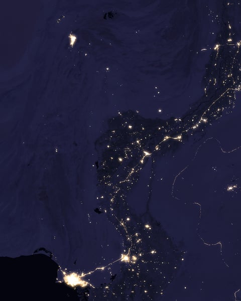 NASA VIIRS satellite image showing the Indus River basin in Pakistan at night with the sinuous shape of the river outlined by the lights of cities Lahore Multan Sukkur and Karachi against the darker desert and mountain landscape