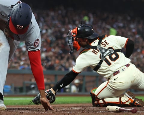 James Wood reaching down to touch home plate to score for Washington Nationals against Giants