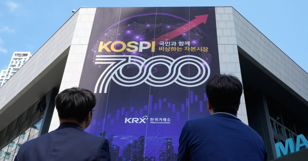 A currency dealer works in front of an electronic board displaying KOSPI and currency exchange rates in Seoul South Korea