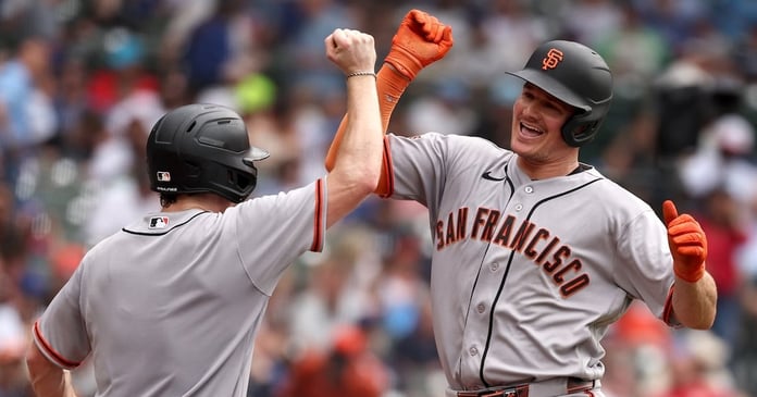 Matt Chapman of San Francisco Giants celebrates with bat boy after hitting three-run home run against Chicago Cubs at Wrigley Field